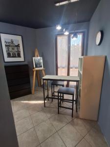 a dining room with a table and chairs and a clock at Appartamenti della Marchesa 2 camere in Montichiari +4 photos