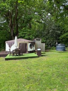 a tent and a table and chairs in a yard at Old Dairy Farm Glamping in Emsworth