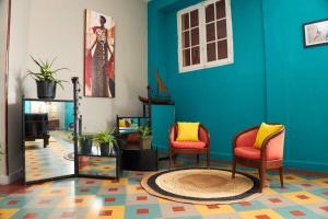 a living room with two chairs and a blue wall at Hotel Joffre in Toamasina