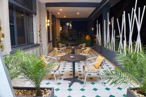 a patio with a table and chairs and plants at Hotel Joffre in Toamasina