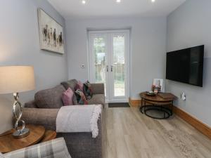 a living room with a couch and a television at Barn 1 in Sandbach
