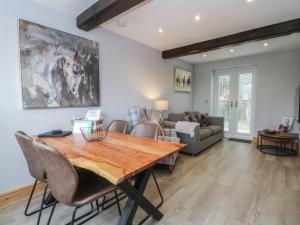 a living room with a wooden table and chairs at Barn 1 in Sandbach