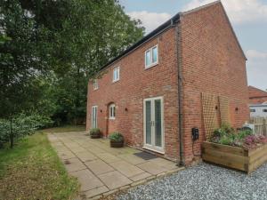 a brick house with a courtyard in front of it at Barn 1 in Sandbach