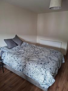 a bedroom with a bed with a gray and white comforter at Spacious ensuite bedroom in Kiltiernan