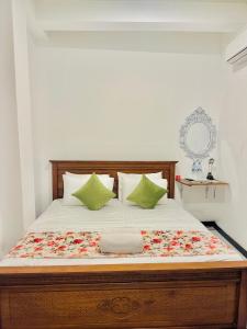 a bedroom with a large bed with green pillows at Sea Breeze Guest House Negombo Beach & Airport in Negombo
