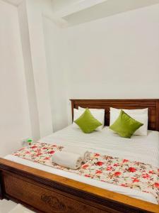 a bedroom with a bed with green pillows at Sea Breeze Guest House Negombo Beach & Airport in Negombo