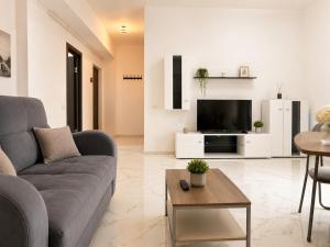 a living room with a couch and a tv at AVI GARDEN Apartments in Constanţa