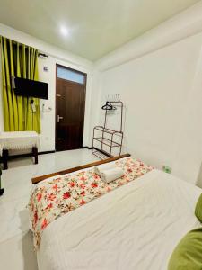 a bedroom with a large white bed with flowers on it at Sea Breeze Guest House Negombo Beach & Airport in Negombo