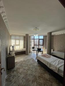 a large bedroom with a bed and a dining room at VAN SERHAT Pansiyon in Ipekyolu