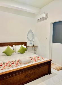 a bedroom with a large bed with green pillows at Sea Breeze Guest House Negombo Beach & Airport in Negombo