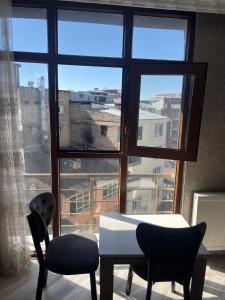 a room with a table and two chairs and a window at VAN SERHAT Pansiyon in Ipekyolu