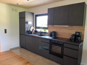 a kitchen with black cabinets and a stove top oven at Ferienwohnung Heiterwang in Heiterwang