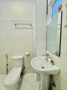 a white bathroom with a toilet and a sink at Sea Breeze Guest House Negombo Beach & Airport in Negombo +92 photos