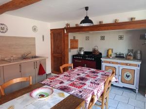 a kitchen with a table with a table cloth on it at Chez Annick in Valfleury