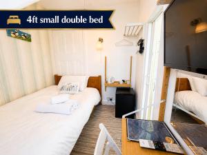 a small double bed in a small double bed room at Holly Trees Guest Accommodation in Seahouses