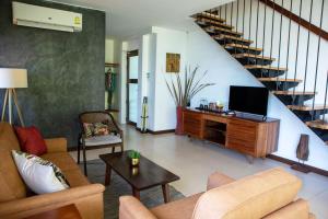 a living room with a couch and a tv at Seaflower Bungalows in Srithanu