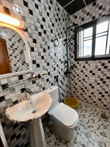 a bathroom with a toilet and a sink at Western Suites in Douala