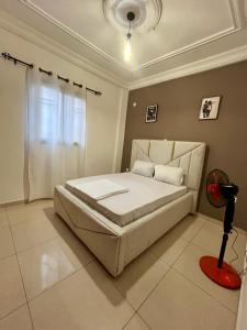 a bedroom with a white bed and a window at Western Suites in Douala