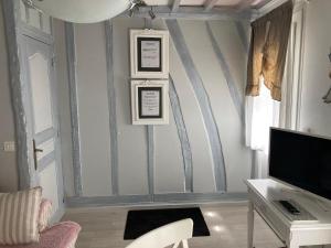 a living room with a wall with grey stripes at Les Chambres de Paule in Thieulloy-lʼAbbaye