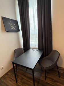 a table and two chairs in a room with a window at Apartmán Pardubice 4 in Pardubice