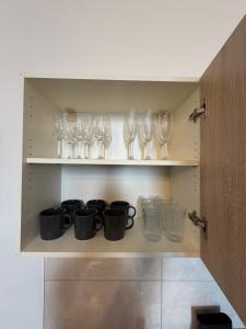 a cupboard with glasses and wine glasses on it at Apartmán Pardubice 4 in Pardubice +5 photos