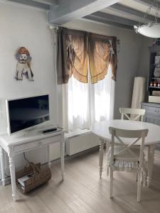 a white dining room with a table and a tv at Les Chambres de Paule in Thieulloy-lʼAbbaye +38 photos