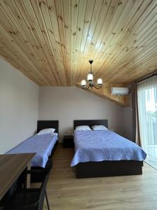 a bedroom with two beds and a wooden ceiling at Corner house in Kobuleti