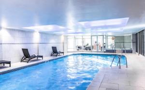 a large pool with two chairs and a table at Wood Hall Hotel & Spa in Wetherby