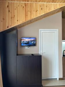 a living room with a tv on a wall at Corner house in Kobuleti