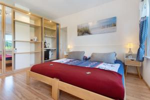 a bedroom with a large red bed in a room at Villa Wiese Störtebecker in Katzow