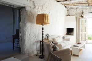 a living room with a couch and a lamp at De Waenhuis Cottage in Calitzdorp