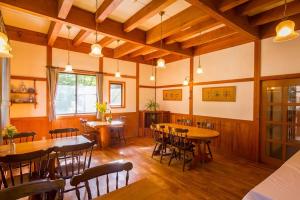 a dining room with wooden tables and chairs at Kamishiro Mountain Lodge in Hakuba