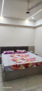 a bed with a colorful blanket on it in a room at Devbhumi Residency in Vadodara