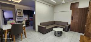 a living room with a couch and a table at Devbhumi Residency in Vadodara