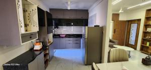 a kitchen with gray cabinets and a refrigerator at Devbhumi Residency in Vadodara