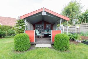 a house with red doors and a table in a yard at Ferienwohnung Am Walde 35177 in Hesel