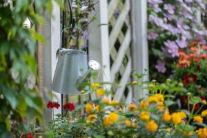 a bird feeder in a garden with flowers at Ferienwohnung Am Walde 35177 in Hesel +32 photos
