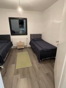 a living room with two beds and a rug at Apartmen Emina 1 in Doglodi