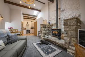 a living room with a couch and a fireplace at The Smithy in Kettlewell