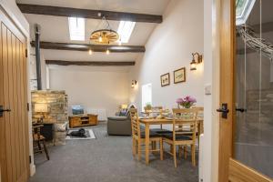 a dining room and living room with a table and chairs at The Smithy in Kettlewell