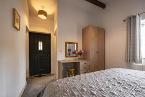 a bedroom with a bed and a table and a mirror at The Smithy in Kettlewell
