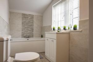 a bathroom with a toilet and a tub and a sink at The Smithy in Kettlewell +18 photos