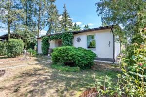 a small white house with a yard at Bungalow an der Havel in Margarethenhof