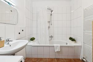 a white bathroom with a tub and a sink at Arbio Monteurzimmer Behnitzer Parking included in Nauen +21 photos