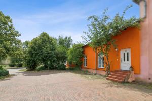 an orange building with a staircase in front of it at Arbio Monteurzimmer Behnitzer Parking included in Nauen