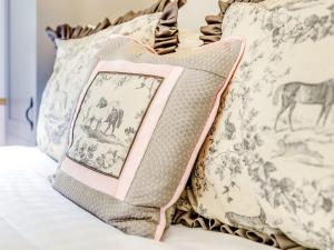 a pile of pillows on a bed with a picture at Snow Drop Hut in Alkborough