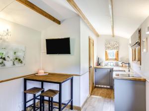 a kitchen with a bar and a tv on the wall at Snow Drop Hut in Alkborough