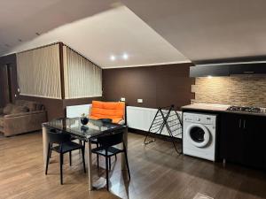 ein Wohnzimmer mit Tisch und Waschmaschine in der Unterkunft Hotel Florencia in Mzcheta