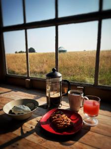 a table with a plate of food on a table with a window at Yurt Ash tree in Saint Briavels