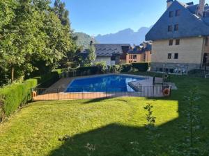a swimming pool in a yard next to a house at Apto Aloha Panticosa | Piscina | WIFI | Vistas in Panticosa